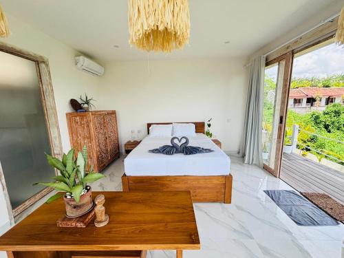 a bedroom with a bed and a wooden table at Trika Surfcamp Bali in Airsatang