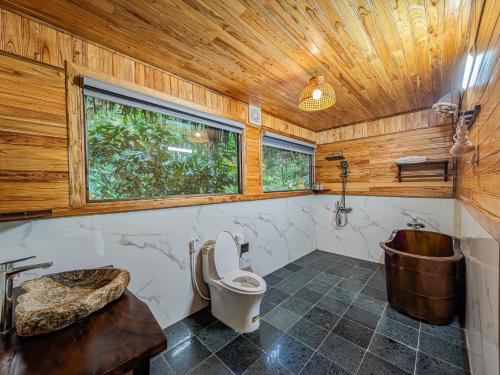 a bathroom with a tub and a toilet and a sink at Hang Lan Ecolodge in Ninh Binh