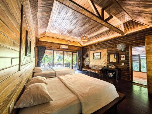 a bedroom with two beds in a room with wooden walls at Hang Lan Ecolodge in Ninh Binh