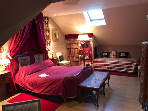 a bedroom with a bed and a bench in it at Résidence La Beauceronne in Ouarville