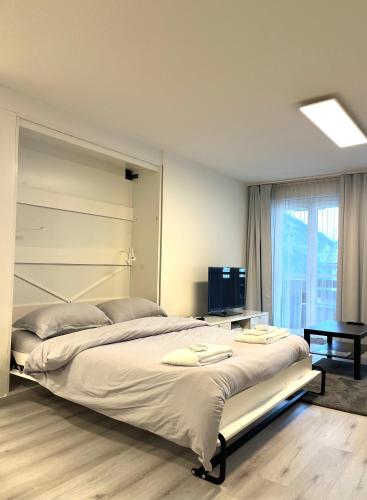 a bedroom with a large bed and a window at Family friendly duplex with free parking in Leukerbad