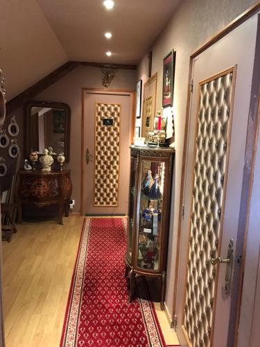 a hallway with a red rug next to a door at Résidence La Beauceronne in Ouarville