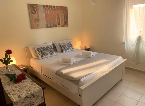 a white bed in a bedroom with a table at Villa Colline Fiorite in Putignano