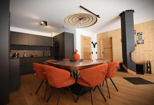 a dining room with a wooden table and orange chairs at La Moutonniere in Levassaix