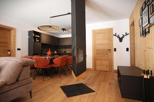 a living room with a dining room table with orange chairs at La Moutonniere in Levassaix