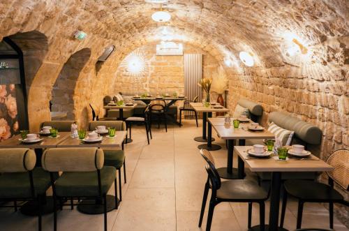 un ristorante con tavoli e sedie e un muro di mattoni di Moris Grands Boulevards a Parigi