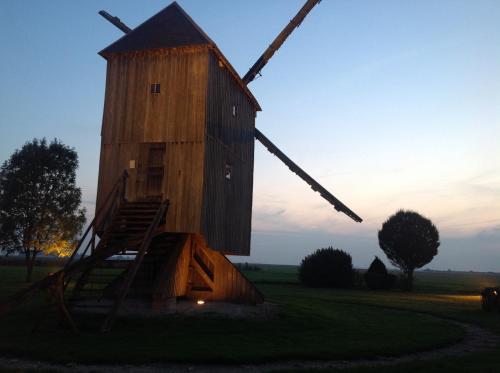 a wooden windmill sitting in the middle of a field at Résidence La Beauceronne in Ouarville