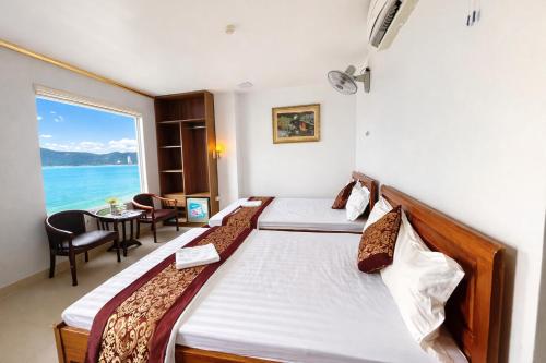 a bedroom with two beds and a view of the ocean at Hong Phuc Hotel 2 Da Nang in Danang