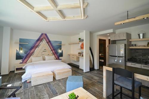 a bedroom with a large bed and a kitchen at Arawan - Boutique Art Hotel - Tannourine in Batroûn