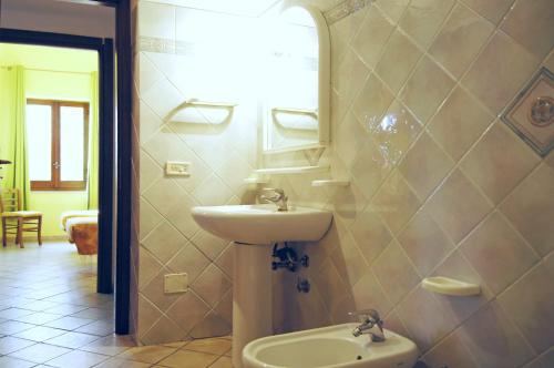 a bathroom with a sink and a toilet and a mirror at Villa Alba Appartamenti in Kamma