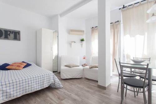 a bedroom with a bed and a table and a chair at Estudio Rambla in Alicante
