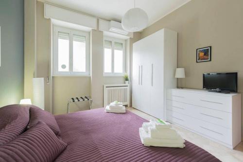 Un dormitorio con una cama morada con zapatos blancos. en Milano Colletta Apartment, en Milán