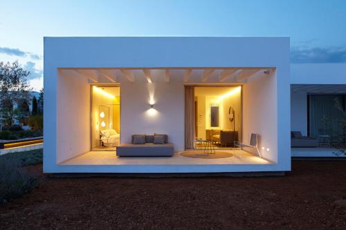 a large white house with a couch and a table at Ca Na Xica - Hotel & Spa in Sant Miquel de Balansat