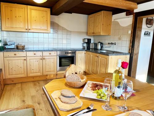 a kitchen with wooden cabinets and a table with wine glasses at Almhütte Ödenhübl in Katschwald