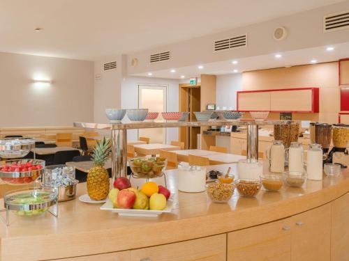 a cafeteria with fruits and other food items on a counter at B&B HOTEL Remilia in Reggio Emilia