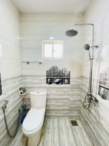 a bathroom with a toilet and a shower at Sasanda Villa in Weligama