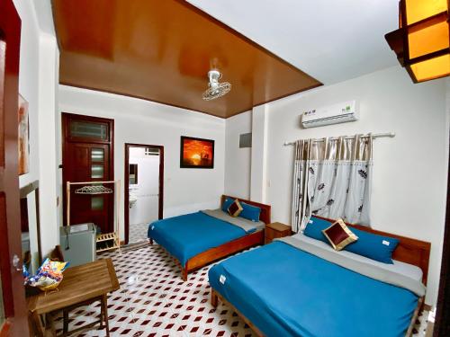 a bedroom with two beds and a table at DK House Homestay in Hoi An