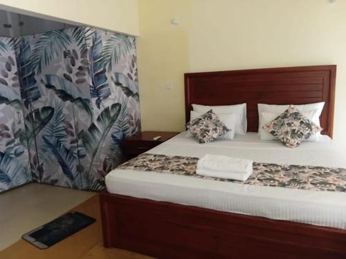 a bedroom with a large bed with white sheets and pillows at Villa Rustic in Negombo