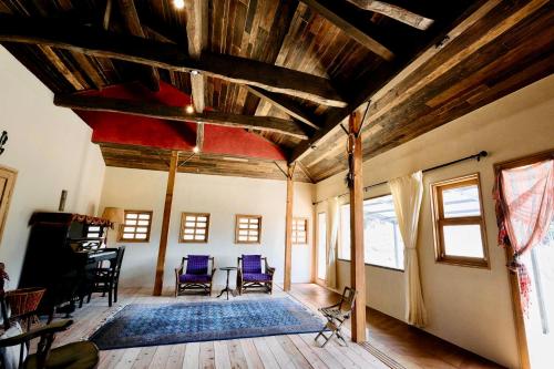 a living room with wooden ceilings and blue chairs at Hotel Namaskar in Naka-yamada