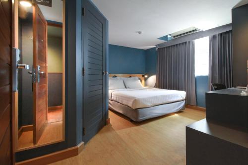 a hotel room with a bed and a television at MyBed Ratchada in Bangkok