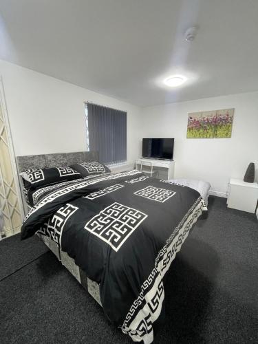 a bedroom with a bed with a black and white comforter at en-suite rooms available for short term in Huddersfield