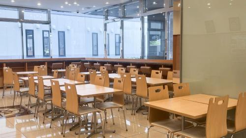 a classroom with tables and chairs and windows at Toyoko Inn Aomori Ekimae in Aomori