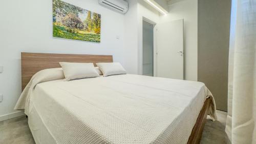 a bedroom with a large bed with white sheets at Cascina Pizzo in San Martino Olearo