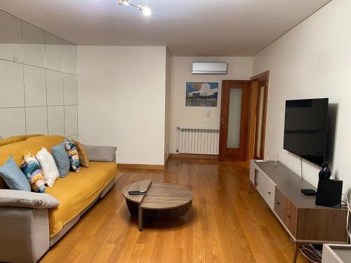 a living room with a couch and a flat screen tv at Ribeiros House Infantado in Loures