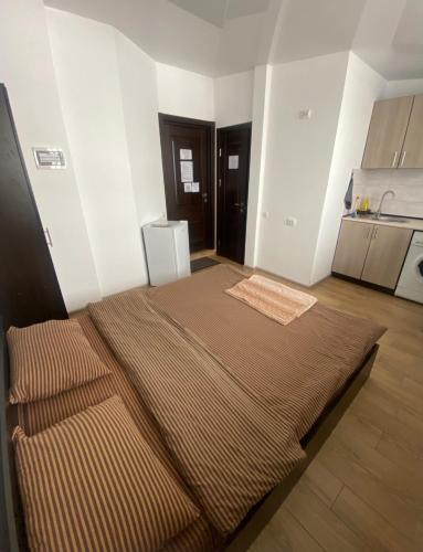a room with a large bed and a kitchen at Студія в центрі міста , 7 поверх без ліфту in Ivano-Frankivsk