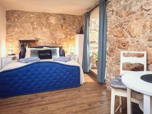 a bedroom with a blue bed in a stone wall at Molo selo area in Stari Grad