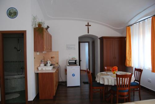 a kitchen and dining room with a table and a kitchen with a microwave at Dvůr U kapličky in Žďár nad Sázavou