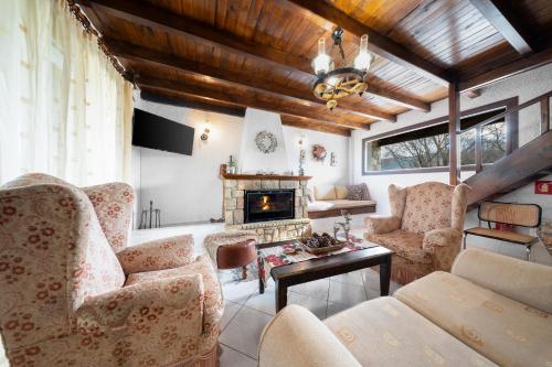 a living room with chairs and a fireplace at Chalet Renata 2 Livadi Arachovas in Kalívia