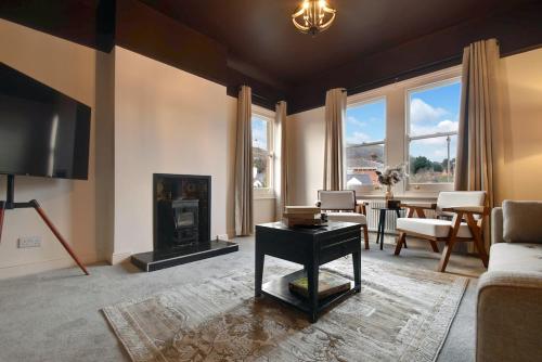 a living room with a couch and a fireplace at Maple Snug- Wyndale Signature Stays in Great Malvern