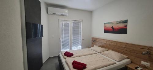 a small bedroom with a bed and a window at Gold Apartmani Kozarac in Kozarac