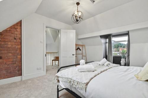a bedroom with a large bed and a brick wall at Maple Snug- Wyndale Signature Stays in Great Malvern