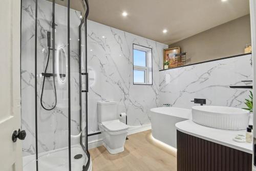 a bathroom with a shower and a toilet and a sink at Maple Snug- Wyndale Signature Stays in Great Malvern