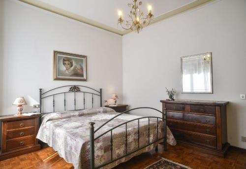 ルッカにあるCasa Paola Luccaのベッドルーム1室(ベッド1台、ドレッサー2台、シャンデリア付)