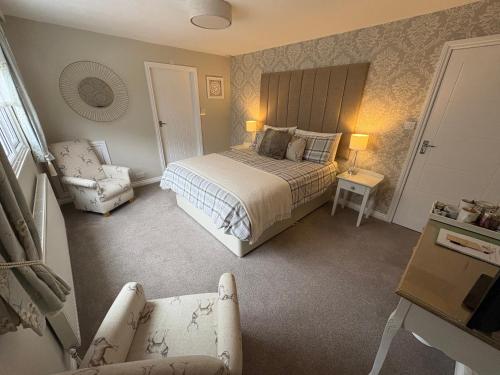 a bedroom with a bed and a chair at Woodland House B & B in Wimborne Minster