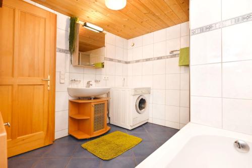 a bathroom with a sink and a washing machine at Ferienhof Steurer in Balderschwang