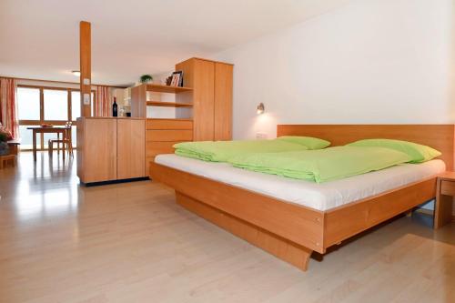a bedroom with a large bed with green sheets at Ferienhof Steurer in Balderschwang