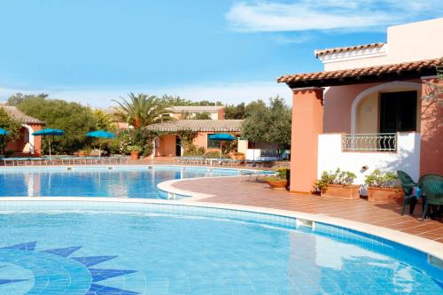 einen Pool in einem Resort mit Stühlen und Sonnenschirmen in der Unterkunft Alba Dorata Resort in Cala Liberotto