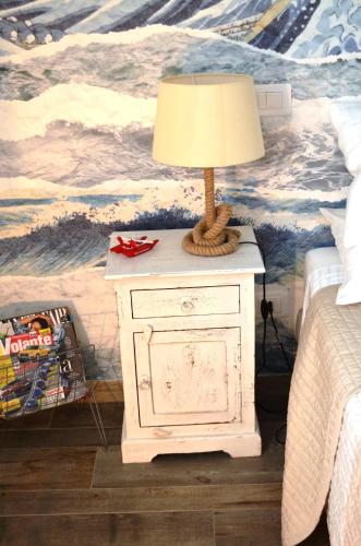 a lamp on a white night stand next to a bed at La Sciabbega B&b in Porto Recanati