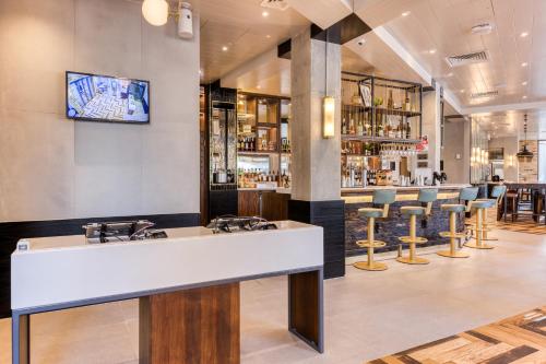 a bar with a white counter and bar stools at hub London - Marylebone in London