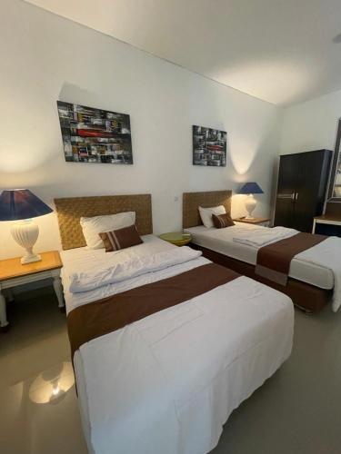 a hotel room with two beds and a desk at Ariani Villa in Jimbaran