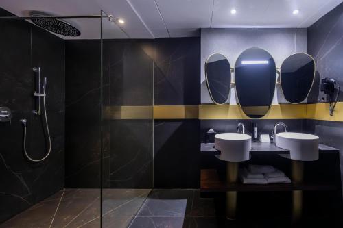 a bathroom with a shower and two sinks and mirrors at Soho Boutique Granada in Granada