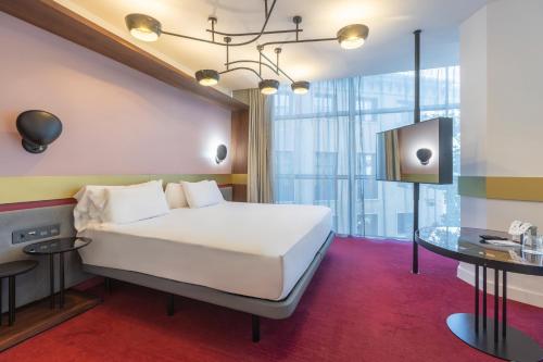 a bedroom with a white bed and a table at Soho Boutique Granada in Granada