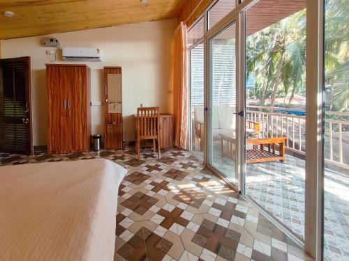 a bedroom with a bed and a view of a patio at The Racha Agonda in Agonda