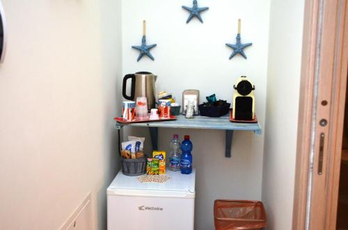 a kitchen with a shelf above a refrigerator at La Sciabbega B&b in Porto Recanati