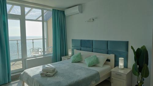 a bedroom with a bed and a large window at Плажни Апартаменти Силвър Бийч - Silver Beach Sea Apartments in Byala