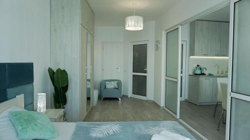 a bedroom with a bed and a chair in it at Плажни Апартаменти Силвър Бийч - Silver Beach Sea Apartments in Byala